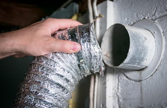 hand removing a pipe from an air duct